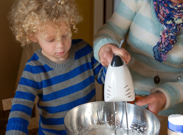 Young child baking at home with a grandparent