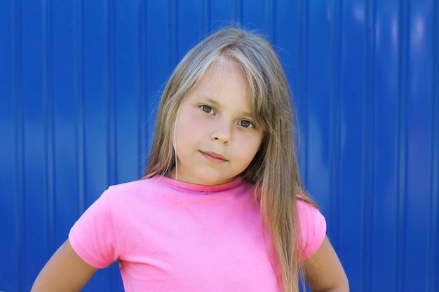 Young child girl in a pink tshirt portrait looking at the camera