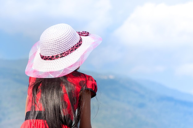 Young child girl red shirt with wear hat on nature background in the blue sky a symbol of leadership success and freedom and travel