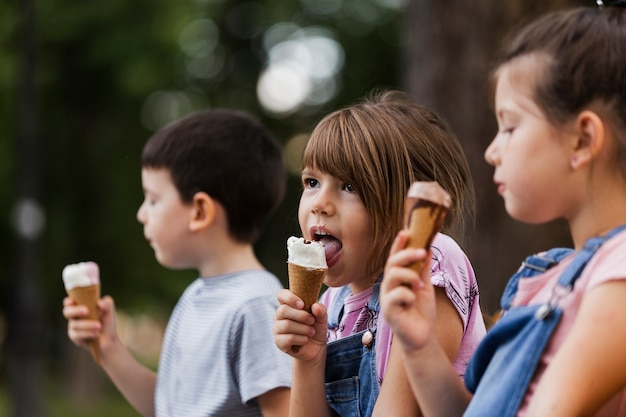 Young children enjoying ice-cream outdoors