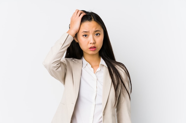 Young chinese business woman isolated being shocked, she has remembered important meeting.