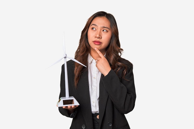 A young Chinese businesswoman proudly holds a windmill symbolizing her commitment