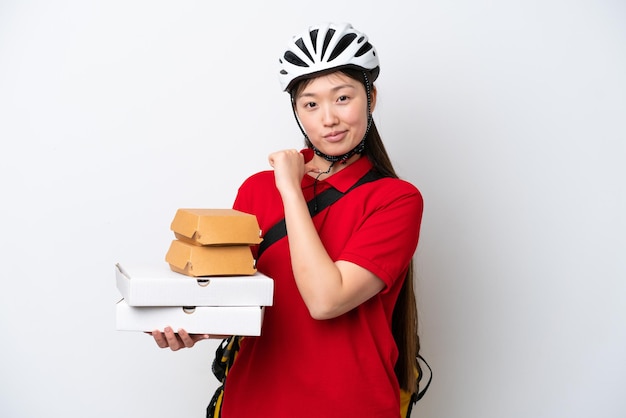 Young Chinese delivery woman taking takeaway food isolated on white background proud and selfsatisfied