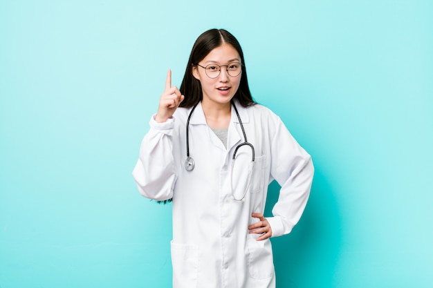 Young chinese doctor woman having an idea, inspiration concept.