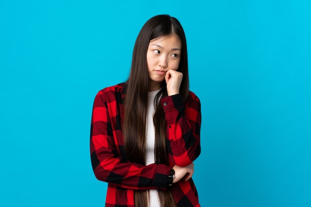 Young Chinese girl isolated with tired and bored expression