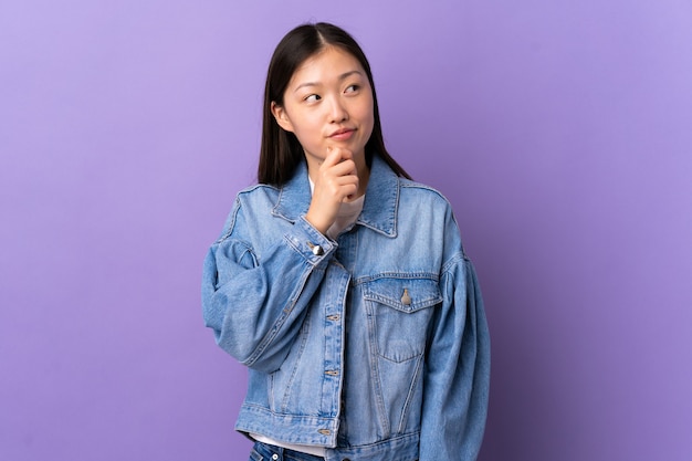 Young Chinese girl over purple and looking up