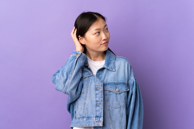 Young Chinese girl over purple thinking an idea