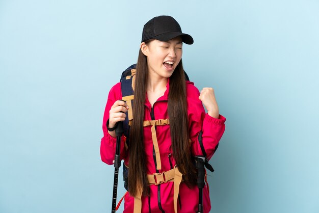 Photo young chinese girl with backpack and trekking poles isolated