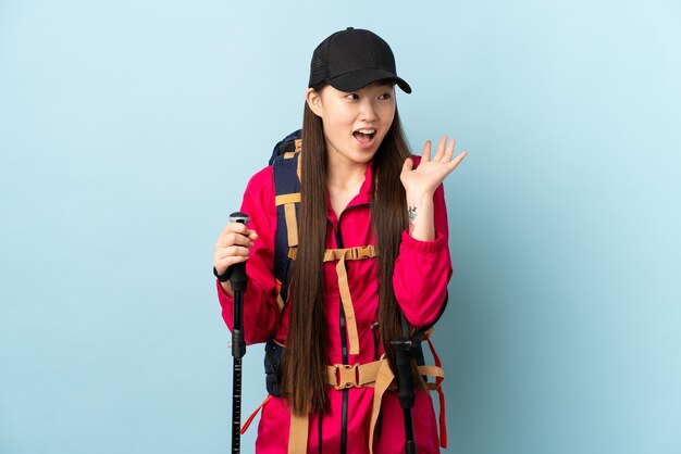 Photo young chinese girl with backpack and trekking poles isolated