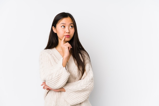 Young chinese woman isolated looking sideways with doubtful and skeptical expression.