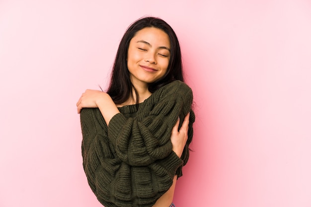 Young chinese woman isolated over pink hugs, smiling carefree and happy.