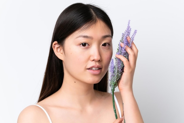 Young Chinese woman isolated on white background holding a lavender plant Close up portrait