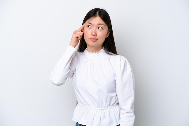 Young Chinese woman isolated on white background making the gesture of madness putting finger on the head