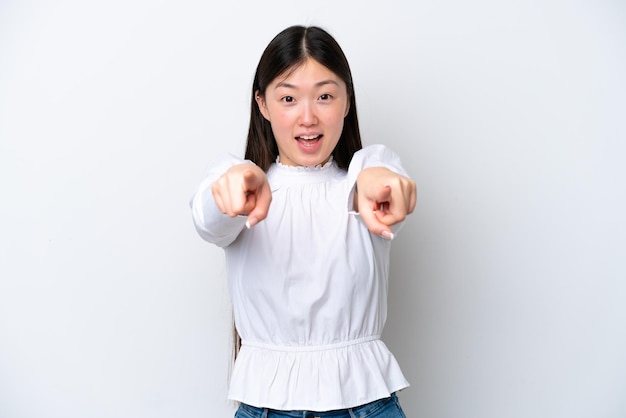 Young Chinese woman isolated on white background surprised and pointing front