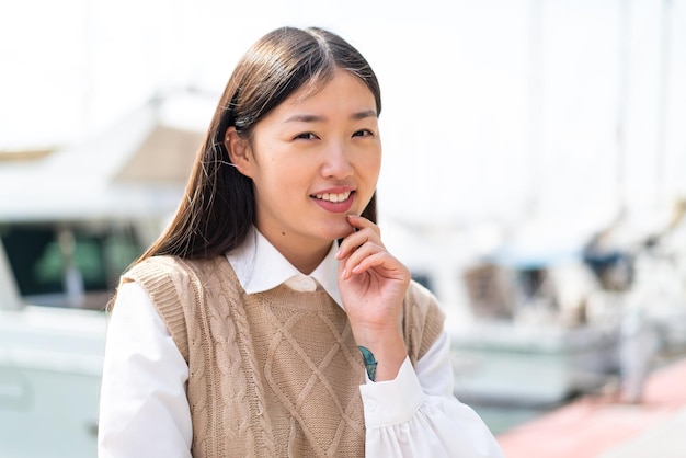 Young Chinese woman at outdoors With happy expression