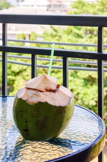 A young coconut ready to eat on a glass table for the summer drink concept