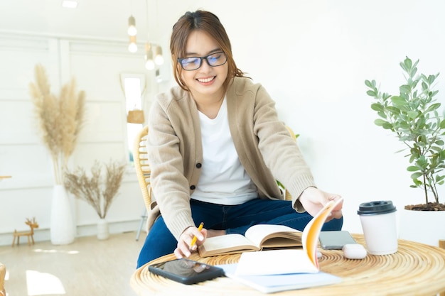 Young collage student reading a book sitting in a chairxA