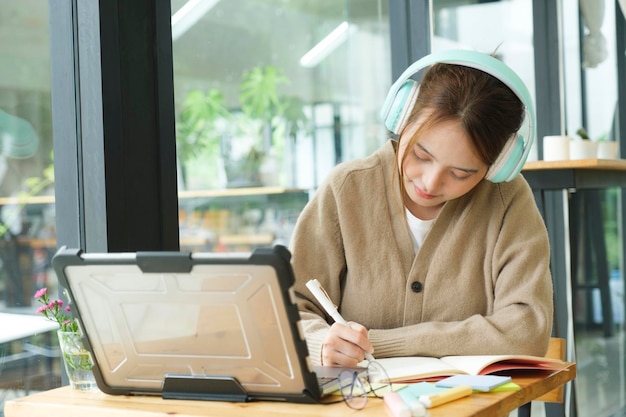 Young collage student using computer and mobile device studying onlinexA