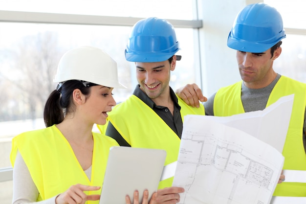  Young colleagues construction workers looking at building plan