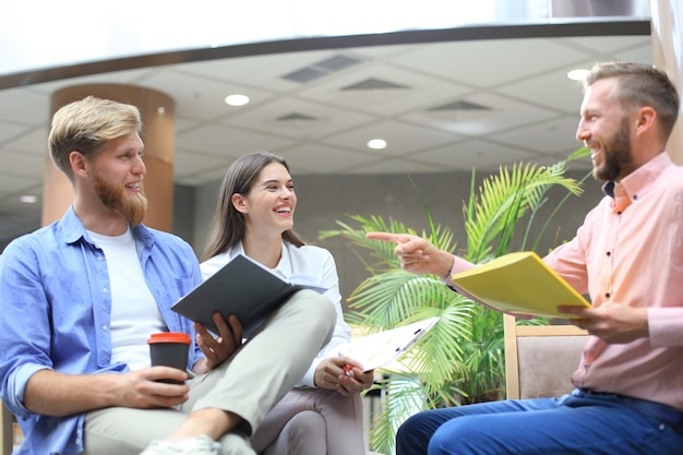 Young colleagues in smart casual wear working while spending time in the office.