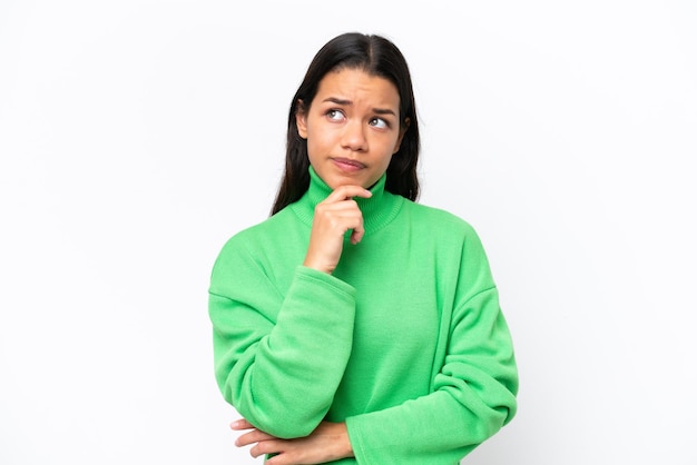 Young Colombian woman isolated on white background having doubts and thinking