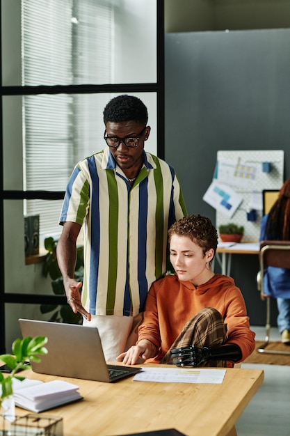 Young confident businessman explaining data to colleague