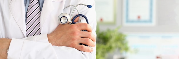 Young and confident male doctor with stethoscope in hands