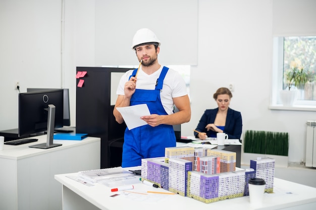 Young construction supervisor taking notes in the office