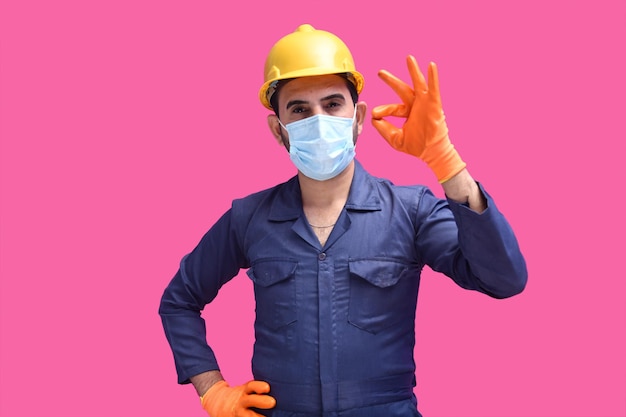 young construction worker wearing mask and showing ok sign indian pakistani model