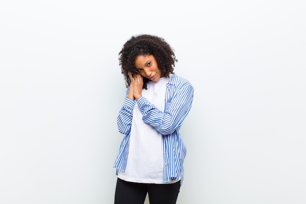 Young cool african american woman feeling in love and looking cute, adorable and happy, smiling romantically with hands next to face