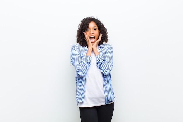 Young cool african american woman feeling shocked and excited, laughing, amazed and happy because of an unexpected surprise