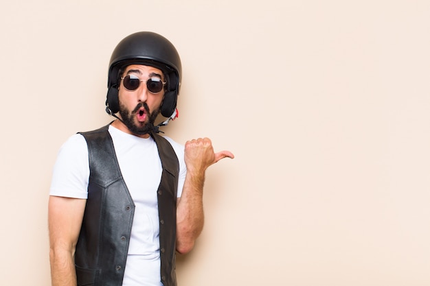 Young cool bearded man with a helmet pointing to the side