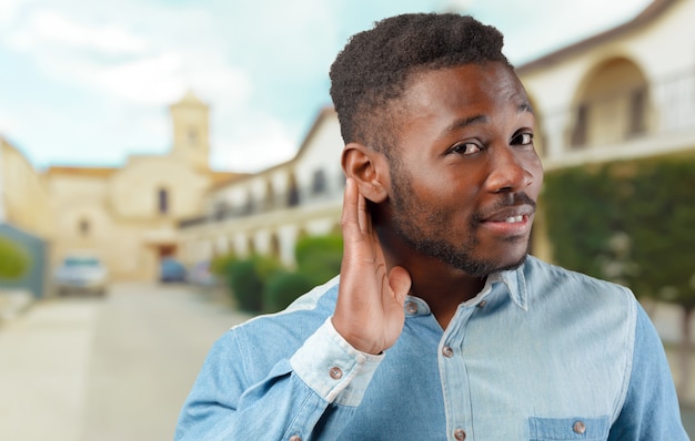 Young cool black man portrait trying to listen