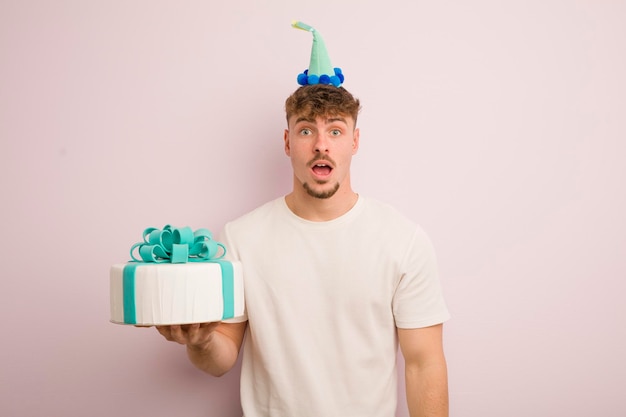 Young cool man looking very shocked or surprised birthday concept