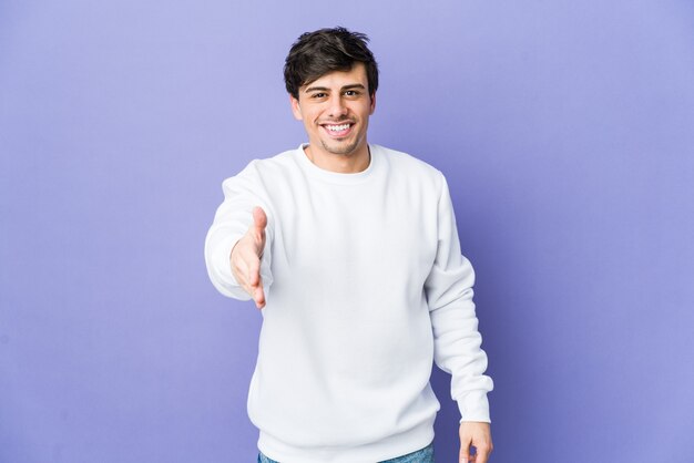 Young cool man stretching hand in greeting gesture