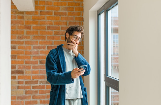 Young cool man waking up at home wearing pajamas