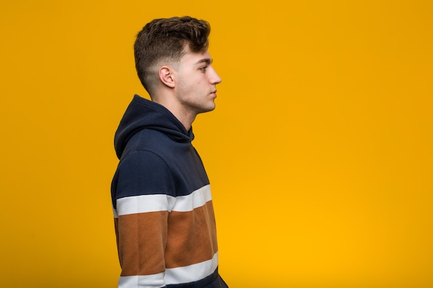 Young cool man wearing a hoodie gazing left, sideways pose.