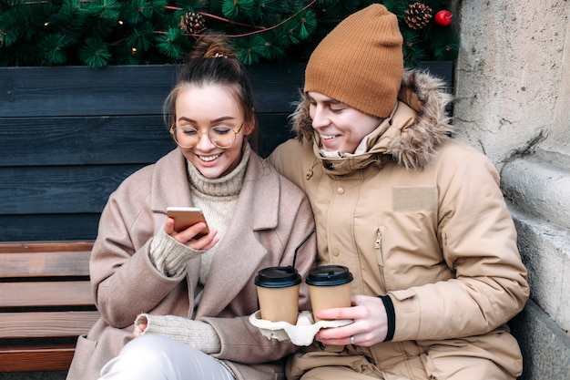 Young couple, beautiful girl and her handsome boyfriend have fun together on the street in cold winter