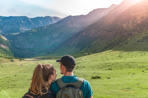 Young Couple in a beautiful valley between mountains during the sunset Discovery Travel concept