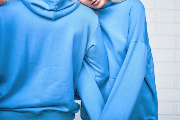 Photo young couple in blue hoodies posing stylishly