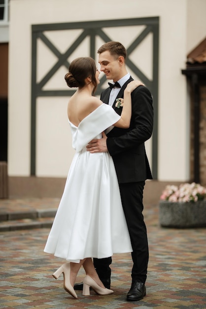 Young couple bride and groom in a white short dress