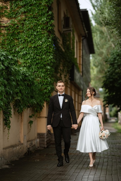 Young couple bride and groom in a white short dress