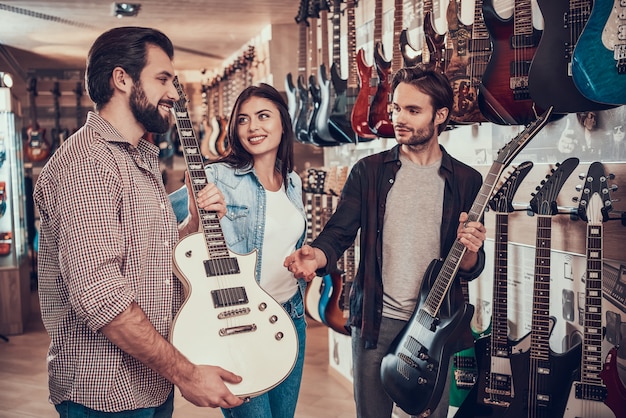 Young couple buy new electric guitar in music store