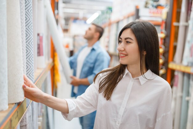 Young couple buying wallcovering in hardware store