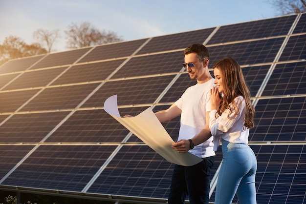 Young couple by a solar module