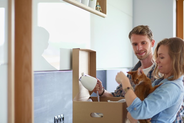 Young couple carrying big cardboard box at new home.Moving house. Young couple.