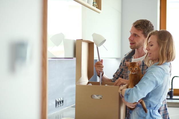 Young couple carrying big cardboard box at new homeMoving house Young couple