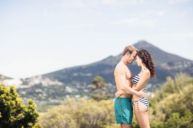 Young couple cuddling each other near pool on a sunny day