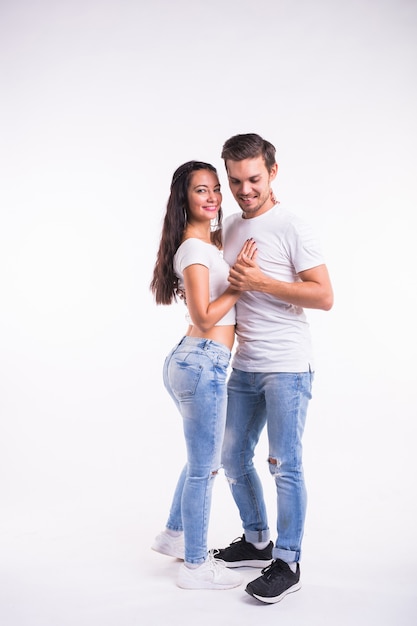 Young couple dancing social dance bachata, merengue, salsa, kizomba. Two elegance pose on white room