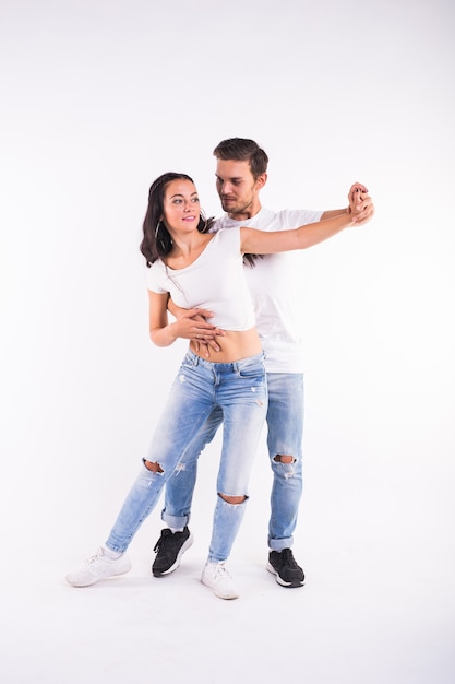 Young couple dancing social latin dance bachata, merengue, salsa. Two elegance pose on white background.